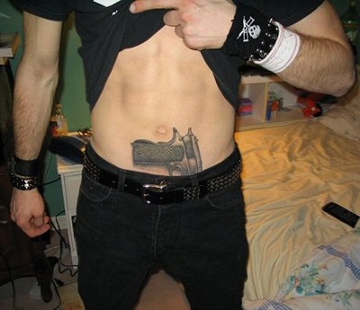  tattoo on his stomach, tucked in his jeans.